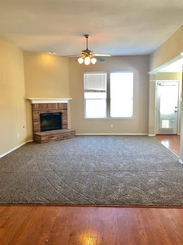 an empty room with fireplace chandelier and windows
