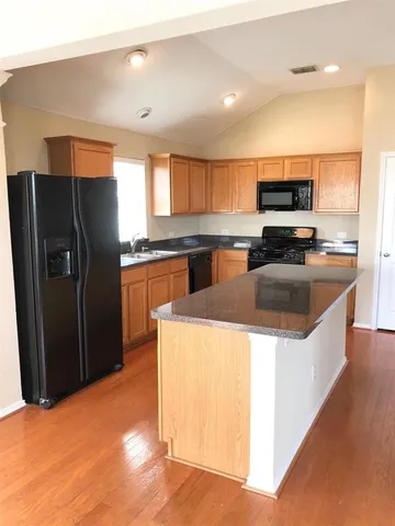 a kitchen with stainless steel appliances granite countertop a refrigerator a sink a stove a microwave and island