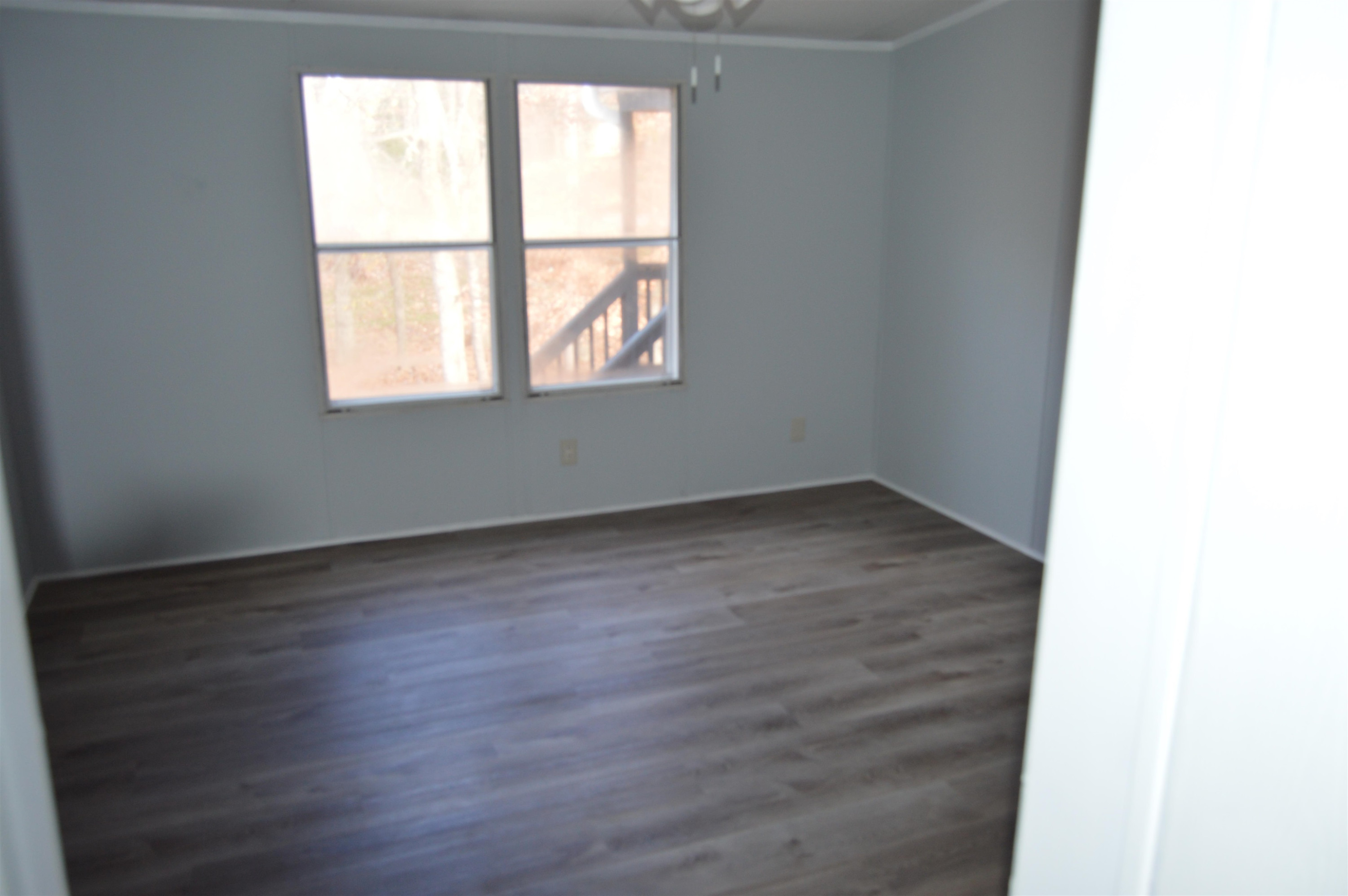 879 Holeman Ashley Road Timberlake, NC 27583 - Photo 6 of 9 an empty room with wooden floor and windows