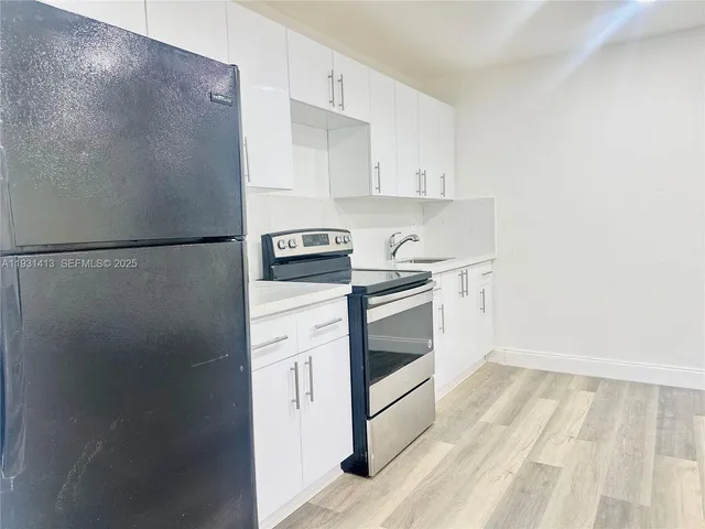 a kitchen with a white cabinets and white appliances