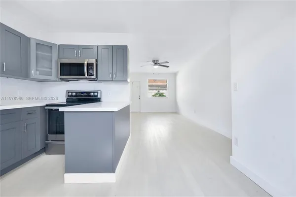 a kitchen with cabinets and a microwave