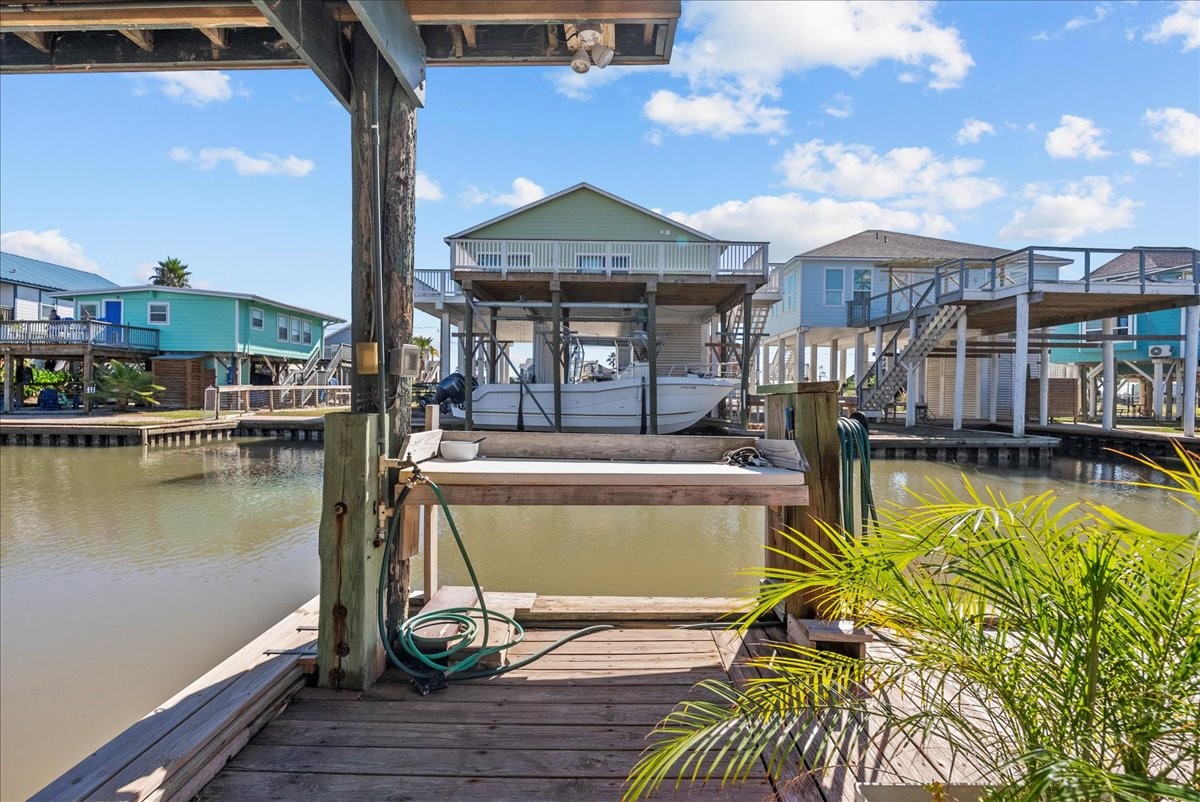 324 Shark Lane Surfside Beach, TX 77541 - Photo 39 of 49 This waterfront property features a private dock with a boat lift, offering direct canal access. The stilted homes provide elevated views and a serene, coastal lifestyle. Perfect for boating enthusiasts.