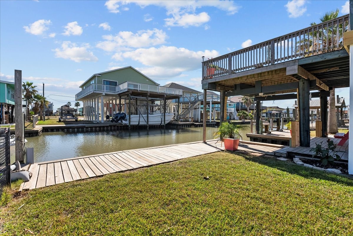 324 Shark Lane Surfside Beach, TX 77541 - Photo 44 of 49 This waterfront property features a charming dock with a spacious deck overlooking a serene canal, ideal for boating enthusiasts. The lush lawn and outdoor seating area offer a perfect space for relaxation and entertaining.