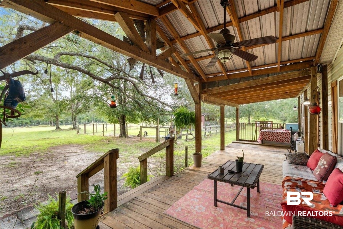 21011 River Road Robertsdale, AL 36567 - Photo 3 of 29 Expansive covered porch featuring a wood-finish ceiling, exposed beams, and a ceiling fan
