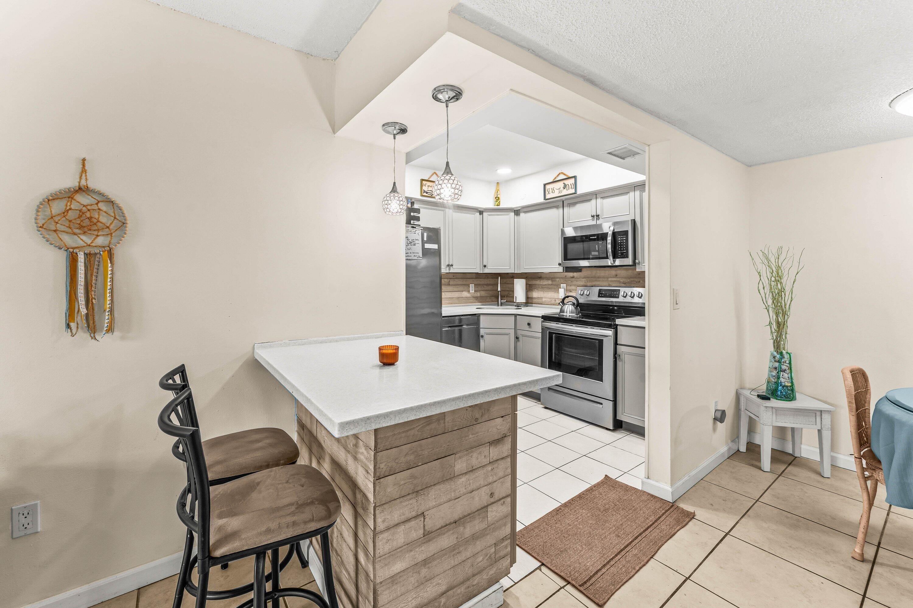 950 South Kanner Highway, Unit C10 Stuart, FL 34994 - Photo 6 of 31 a kitchen with stainless steel appliances kitchen island granite countertop a table chairs and a refrigerator