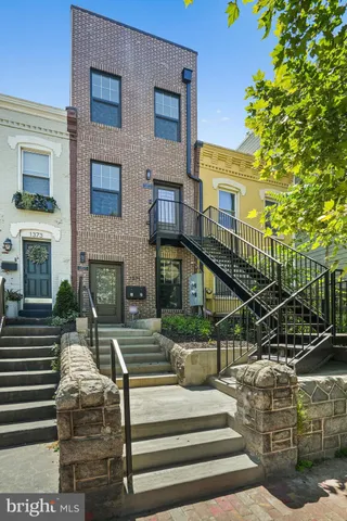 a view of house with outdoor space and lots of trees in the background