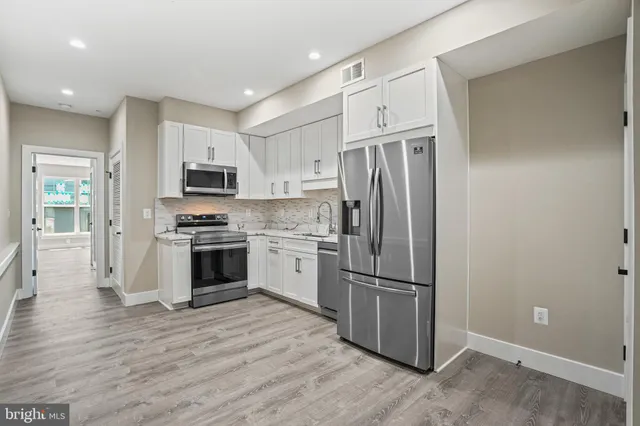 a kitchen with stainless steel appliances a refrigerator sink and microwave