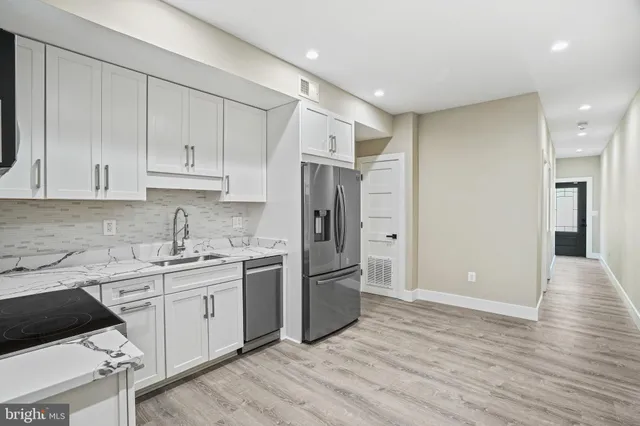 a kitchen with stainless steel appliances granite countertop a refrigerator and a stove top oven