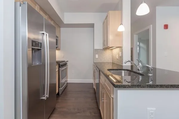 a kitchen with stainless steel appliances granite countertop a refrigerator and a sink