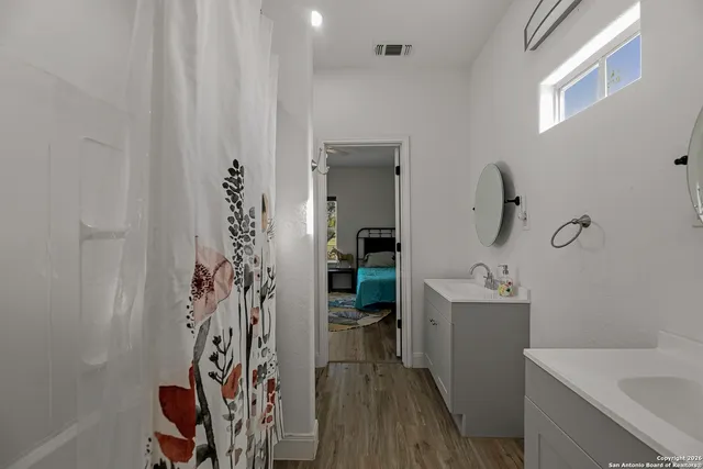a bathroom with a sink a mirror and a shower curtain