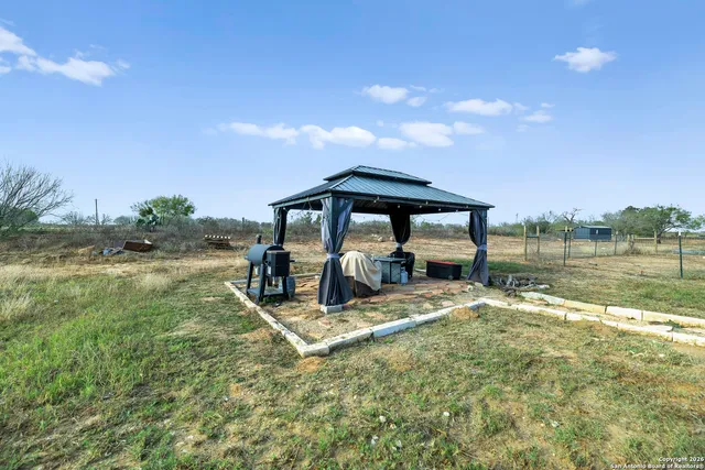 a view of house with garden space and car parked