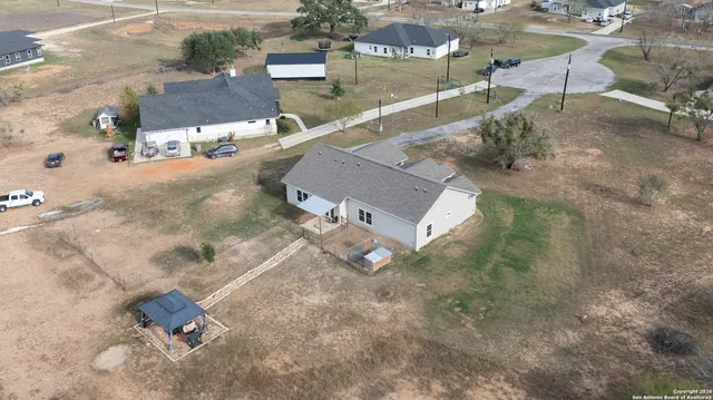 a view of a dry yard with large trees