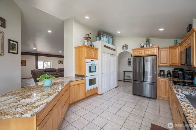 a kitchen with stainless steel appliances granite countertop a refrigerator and a sink