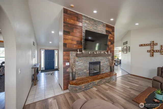 a view of a livingroom with a fireplace wooden floor and staircase
