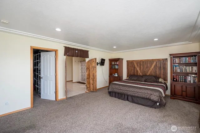 a spacious bedroom with a bed and a walk in closet