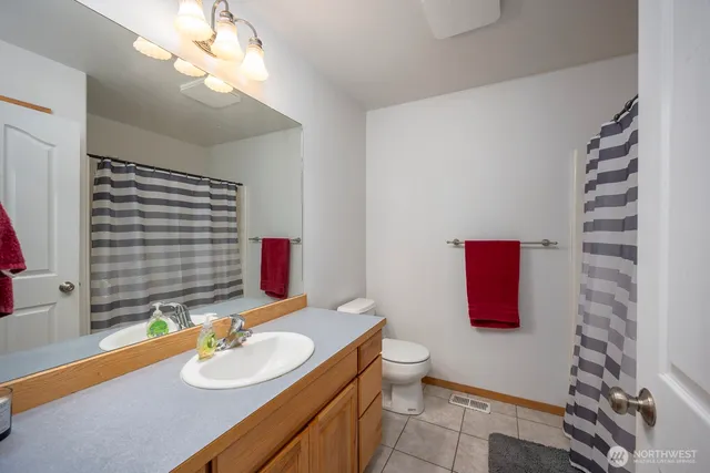 a bathroom with a sink vanity mirror and toilet