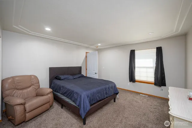 a bedroom with a bed couch and a window