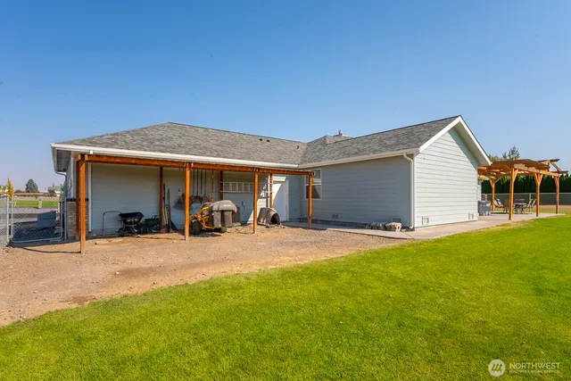 a view of a house with floor to ceiling windows and yard