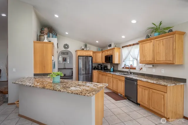 a kitchen with granite countertop a sink and white cabinets