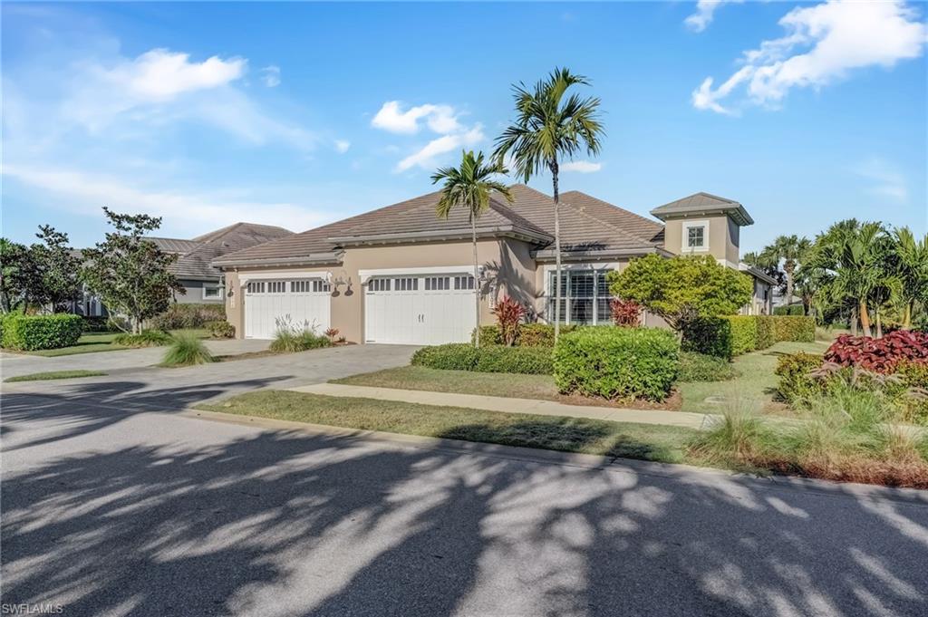 7002 Dominica Drive Naples, FL 34113 - Photo 1 of 45 View of front of home with stucco siding, driveway, and a garage