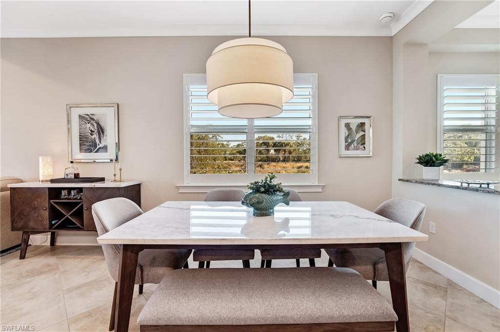 7002 Dominica Drive Naples, FL 34113 - Photo 10 of 45 Dining area with healthy amount of natural light, ornamental molding, and light tile patterned flooring