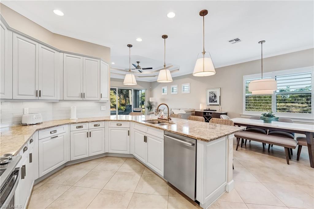 7002 Dominica Drive Naples, FL 34113 - Photo 15 of 45 Kitchen with hanging light fixtures, light stone countertops, stainless steel appliances, and recessed lighting