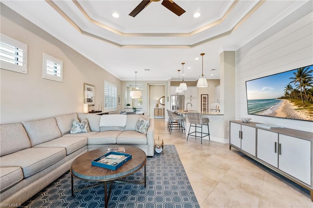 7002 Dominica Drive Naples, FL 34113 - Photo 20 of 45 Living area with crown molding, ceiling fan, a tray ceiling, recessed lighting, and light tile patterned flooring