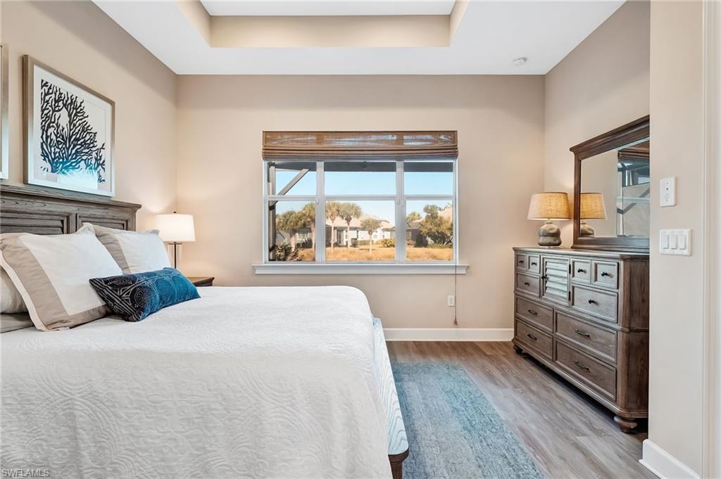 7002 Dominica Drive Naples, FL 34113 - Photo 23 of 45 Bedroom featuring light wood finished floors and a tray ceiling
