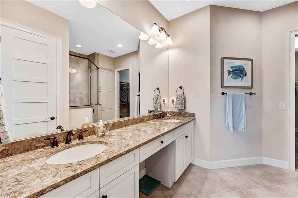 7002 Dominica Drive Naples, FL 34113 - Photo 25 of 45 Full bathroom featuring double vanity, a walk in closet, and light tile patterned floors