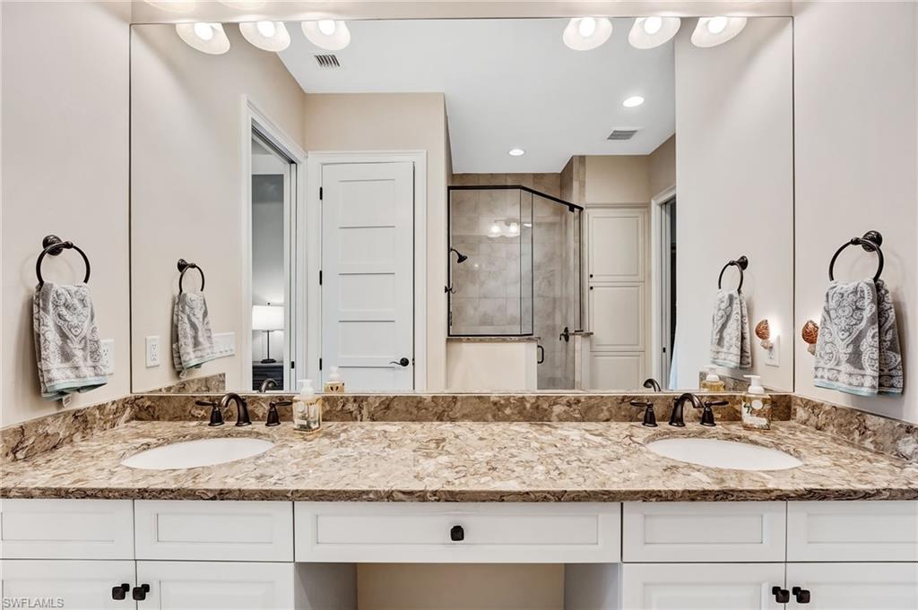 7002 Dominica Drive Naples, FL 34113 - Photo 26 of 45 Bathroom featuring double vanity and a shower stall