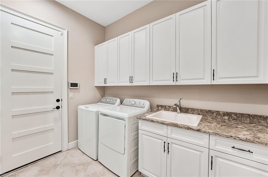 7002 Dominica Drive Naples, FL 34113 - Photo 35 of 45 Laundry room featuring cabinet space, independent washer and dryer, and light tile patterned floors