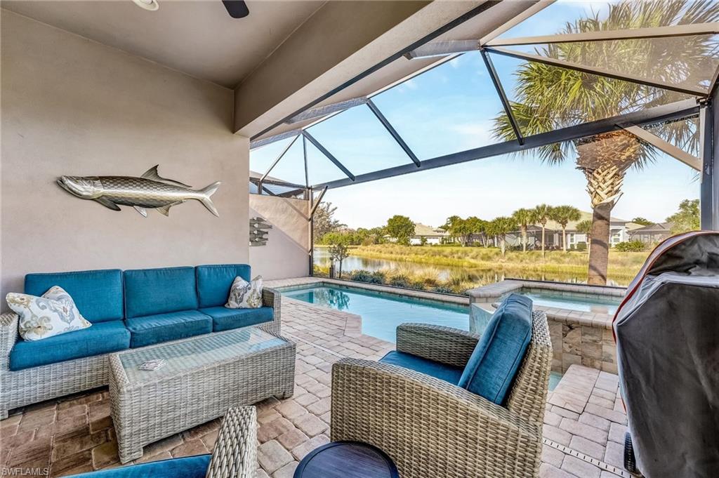 7002 Dominica Drive Naples, FL 34113 - Photo 37 of 45 View of patio featuring a lanai, a sunroom, area for grilling, an outdoor hangout area, and a water view
