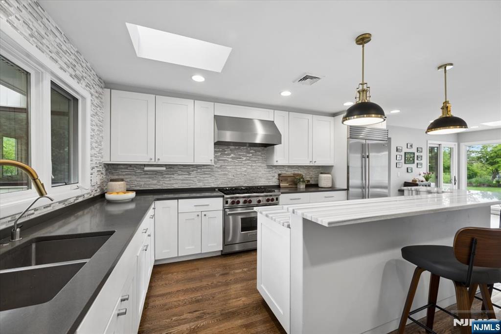39 Eagle Nest Road Morris Township, NJ 07960 - Photo 18 of 43 a kitchen with stainless steel appliances granite countertop a sink a stove and a wooden floors