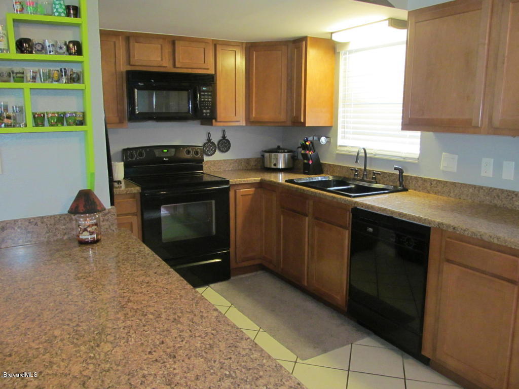 7000 Bryant Road Cocoa, FL 32927 - Photo 5 of 13 a kitchen with a sink stove top oven and microwave