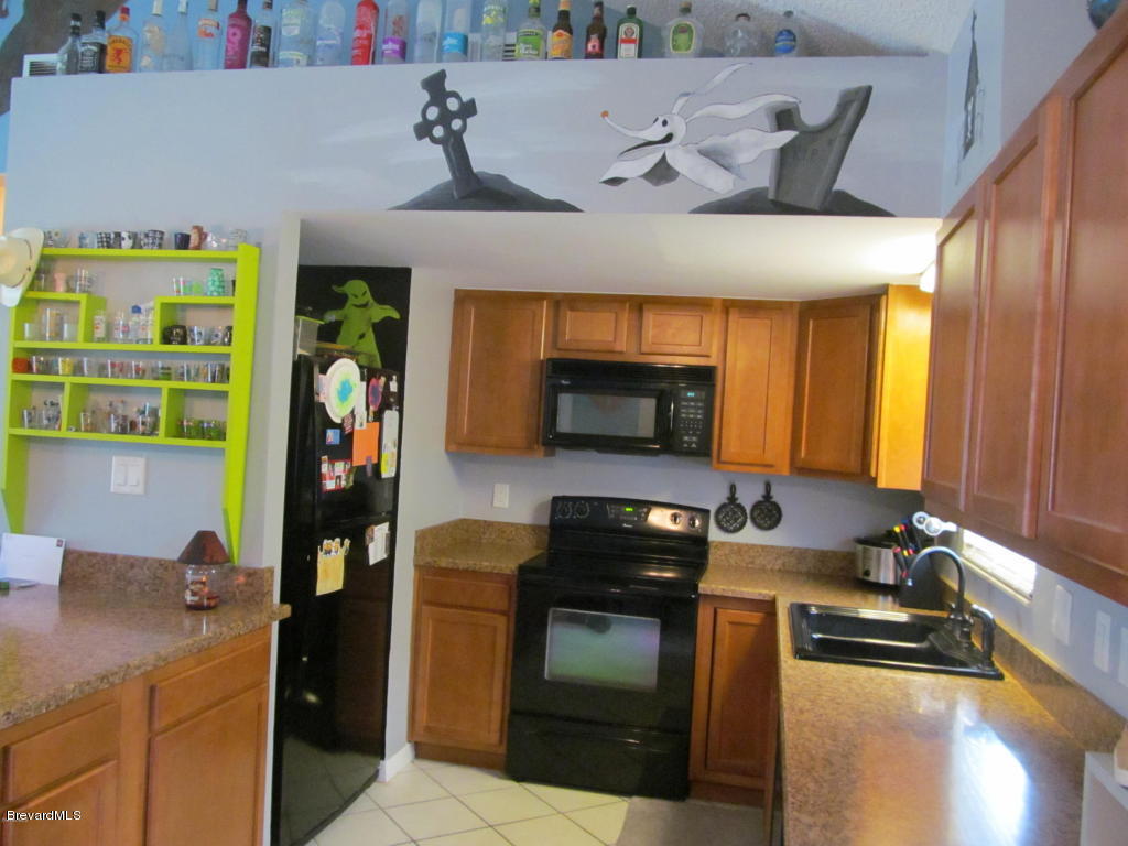 7000 Bryant Road Cocoa, FL 32927 - Photo 7 of 13 a kitchen with stainless steel appliances granite countertop a sink and a stove
