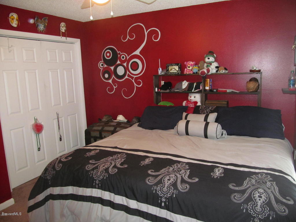 7000 Bryant Road Cocoa, FL 32927 - Photo 9 of 13 a bedroom with a bed and a table