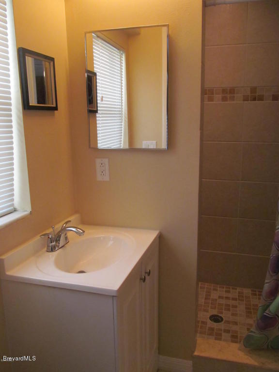 7000 Bryant Road Cocoa, FL 32927 - Photo 10 of 13 a bathroom with a sink and a mirror