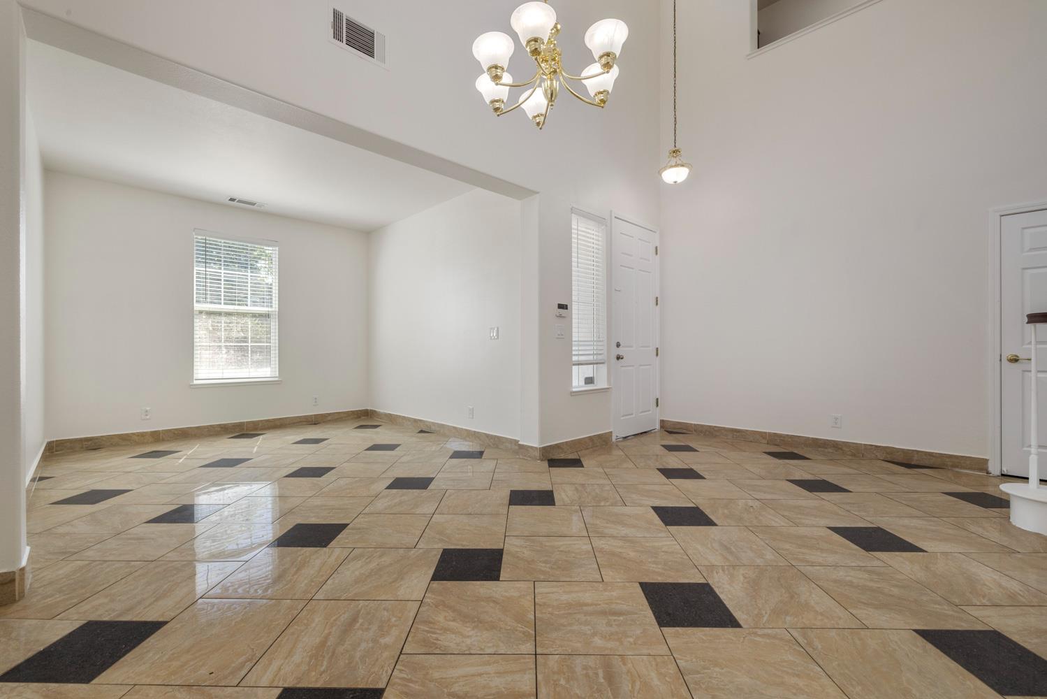 3105 Ripple Court Modesto, CA 95355 - Photo 7 of 46 a view of a big room with a chandelier fan and windows