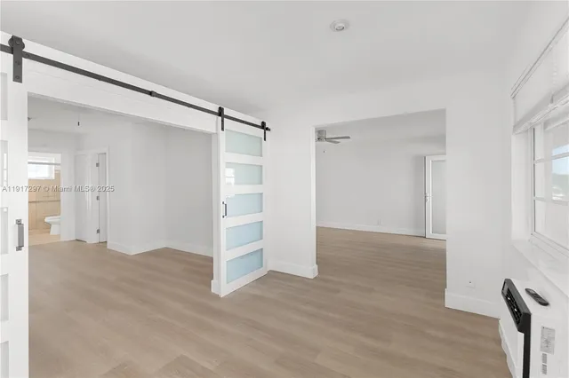 a view of empty room with wooden floor and entryway