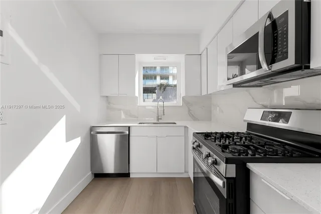 a kitchen with a sink stove top oven and cabinets