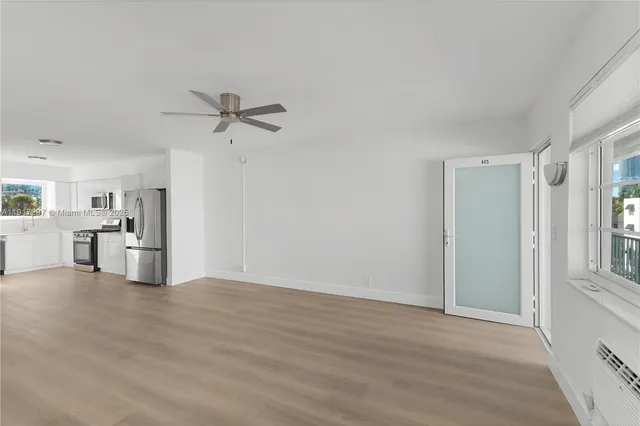 a view of a kitchen with wooden floor and a ceiling fan