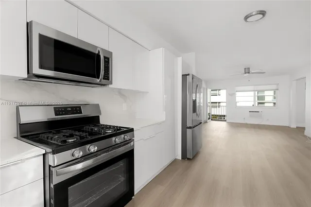 a kitchen with stainless steel appliances a stove a microwave oven cabinets and a counter top space