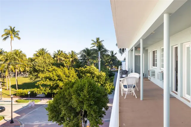 a porch with a table and chairs and potted plants