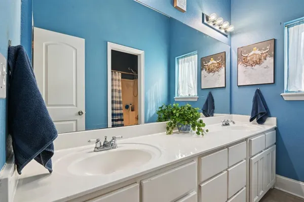a bathroom with a double vanity sink and a mirror