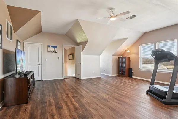 a view of a livingroom with wooden floor and a ceiling fan
