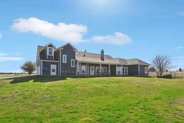 a large house with a big yard and large trees