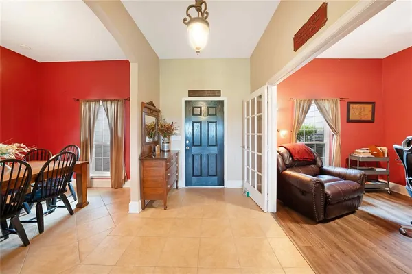 a living room with lots of chairs and a view of kitchen