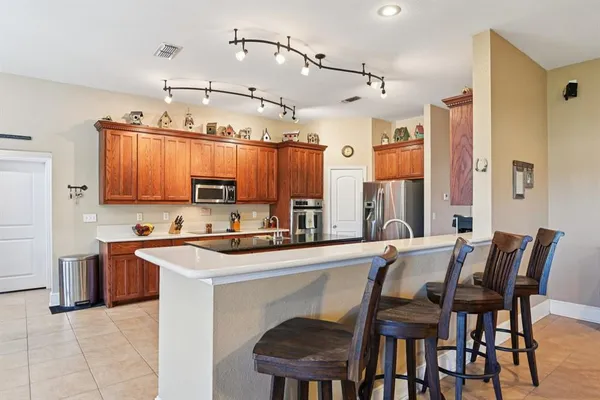 a kitchen with stainless steel appliances a table chairs and a refrigerator