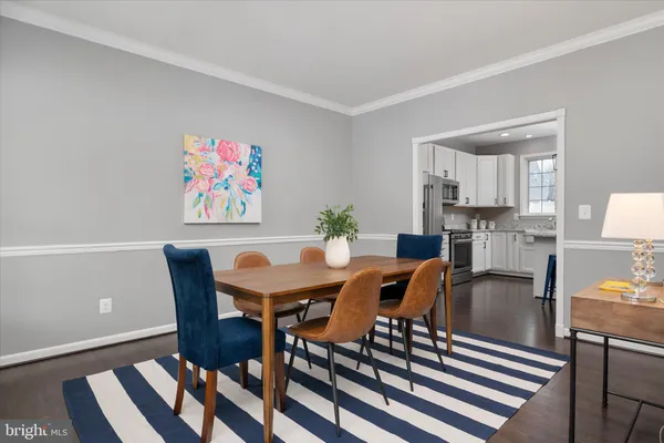 a kitchen with stainless steel appliances granite countertop a stove a sink dishwasher and white cabinets with wooden floor