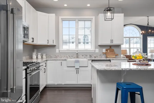 a kitchen with stainless steel appliances granite countertop a stove a refrigerator a sink a stove a microwave and island